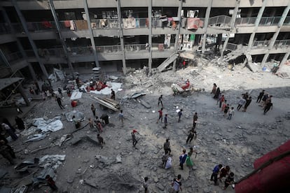 Un grupo de palestinos inspecciona este lunes una escuela de la UNRWA bombardeada por Israel. 