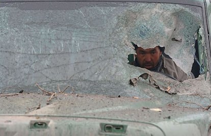 El conductor de un cami&oacute;n mira a trav&eacute;s del parabrisas destrozado que ha sido alcanzado por un ataque terrorista talib&aacute;n en Kabul (Afganist&aacute;n).