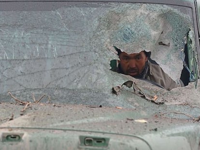 El conductor de un cami&oacute;n mira a trav&eacute;s del parabrisas destrozado que ha sido alcanzado por un ataque terrorista talib&aacute;n en Kabul (Afganist&aacute;n).