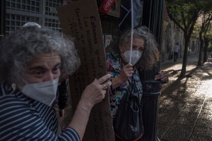 Dos manifestantes se refugian de un cañón de agua, este miércoles en Santiago.
