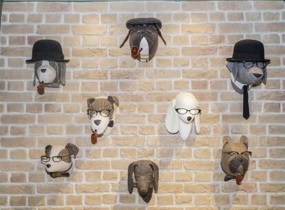 Cabezas de perro en peluches en la pared de una boutique que vende ropa y suplementos para estas mascotas.