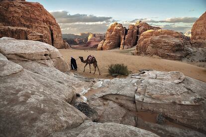 Um homem avança sozinho com seu camelo em Wadi Rum, um deserto de pedra na Jordânia declarado Patrimônio Mundial pela Unesco. Ano 2019.