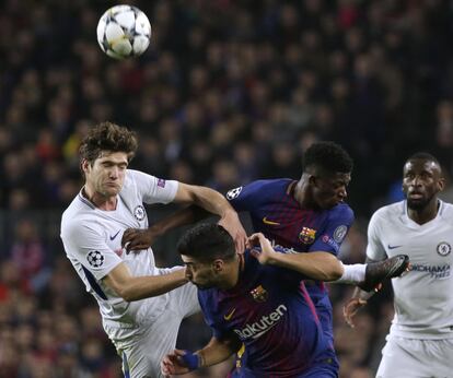 Marcos Alonso (izquierda) y Luis Suárez saltan para golpear el balón.