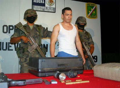 Omar Ibarra, alias 'El 34', custiodado por dos militares en la presentación ante los medios de la operación que ha culminado con su detención en Monterrey, al noreste del país. El arrestado, ex policía de elite, entrenaba a sicarios para el cartel de los hermanos Beltrán Leyva.