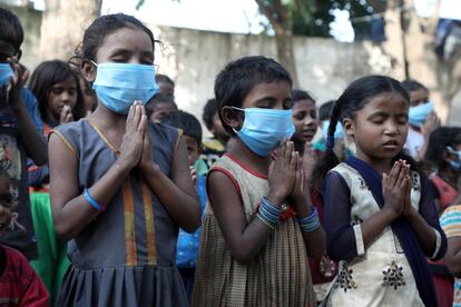 Un grupo de niños reza al comenzar el día en la escuela de Sangharsh Vidya Kendra en uno de los arrabales de Jammu, India, con motivo de la celebración del Día Universal del Niño, cuando Unicef y Cáritas han advertido del "riesgo real" de que se pierda toda una generación de niños en "situación de vulnerabilidad", "emocionalmente impactados" con la situación creada por la pandemia y expuestos aun a más factores de exclusión social.