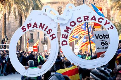 Manifestants amb unes manilles amb el missatge "Democràcia espanyola?".