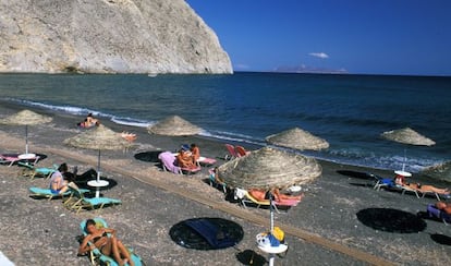 La roca de Mesa Vouno vigila la espectacular playa de Perissa en Santorini (Grecia).