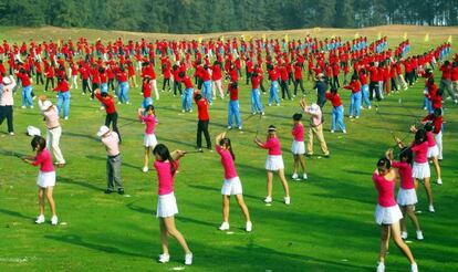 Centenares de aficionados al golf practican el deporte en Hainan (China).