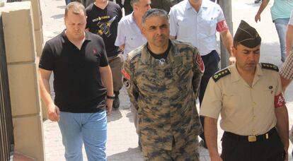 El general Bekir Ercan, en el centro, es conducido este domingo ante el juez en Adana, Turqu&iacute;a.