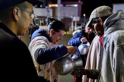 Migrantes venezolanos esperan ante la oficina de inmigración del puente Rumichaca en Tulcan (Ecuador) antes de cruzar a Ipiales (Colombia).