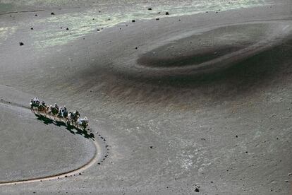 Turistas pase&aacute;ndose en camello en el Echadero de Camellos, a las puertas del parque nacional de Timanfaya, en Lanzarote.