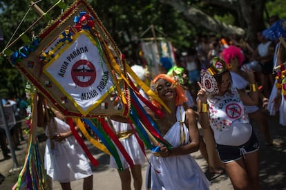 Participantes de um desfile com uma bandeira que se refere à propagação do Zika Vírus no Rio.