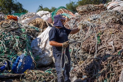 Un trabajador selecciona cuerdas para que se trituren y sean recicladas.