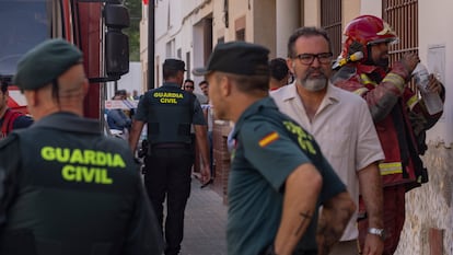 Agentes de la Guardia Civil y bomberos, en los alrededores de la vivienda incendiada en Guillena (Sevillla), este domingo.