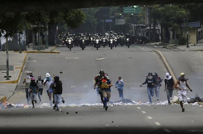 Varios manifestantes corren delante de las fuerzas de seguridad durante una protesta contra el Gobierno venezolano en Caracas, el 22 de junio de 2017.
