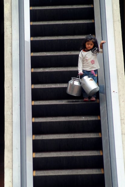 Tomé esta fotografía en la ciudad de Cuenca (Ecuador) en 2008, después de caminar casi una hora tras esa niña a la que había encontrado vendiendo flores junto a su madre en la calle. Una vez que consiguieron dinero suficiente, la pequeña se dirigió a comprar leche a un centro comercial donde sus escaleras eléctricas contrastaban con la pobreza de la niña. Ella me llamó la atención por su actitud de entereza y porque no estaba en el colegio, pese a que era un día escolar.