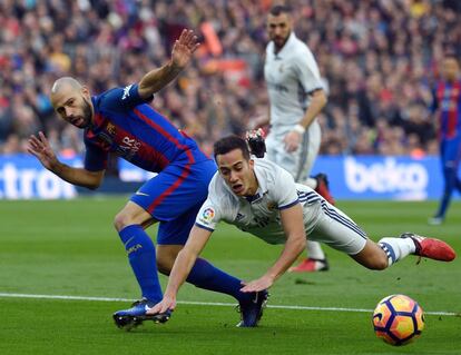 Lucas Vázquez (derecha) del Real Madrid cae al suelo durante una jugada con Javier Mascherano (izquierda) del FC Barcelona.