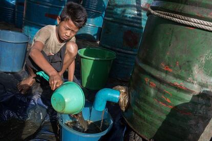 Los trabajadores novatos comienzan ganando 1.000 kyats (unos 3,5 euros). Los experimentados obtienen hasta cuatro veces más por una jornada. En la imagen, un joven trabajador birmano vierte el aceite en un cubo que luego se transferirá a un barril mayor.