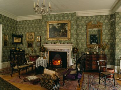 Salón de estilo eduardiano con papel tapiz verde de William Morris.