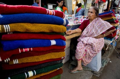 Una anciana espera algún cliente en su puesto de un mercado callejero en Gauhati (India), el 7 de marzo.