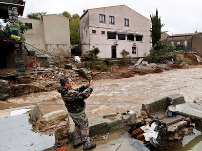 Un hombre fotografía casas dañadas por las inundaciones en Villegailhenc (Francia).