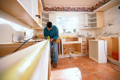 Un operario monta la cocina de una vivienda.