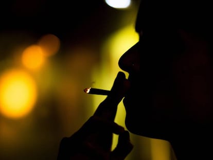 Una socia fuma un porro en un club cann&aacute;bico. 