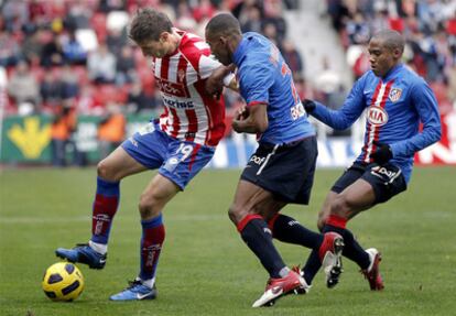 Sebastián Eguren protege el balón ante Perea y Elías.