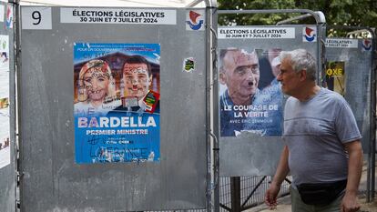 Un peaton pasa junto a un cartel electoral de líderes del Rassemblement National, Marine Le Pen y Jordan Bardella