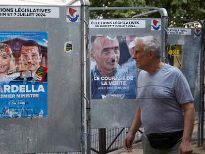 Un peaton pasa junto a un cartel electoral de líderes del Rassemblement National, Marine Le Pen y Jordan Bardella