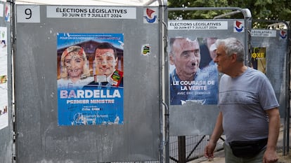 Un peaton pasa junto a un cartel electoral de líderes del Rassemblement National, Marine Le Pen y Jordan Bardella