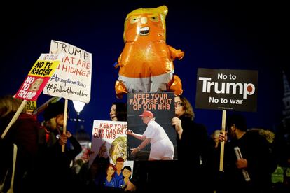 Varios manifestantes sujetan pancartas anti-Trum como protesta por la presencia del mandatario en la cumbre de la OTAN, en Londres (Reino Unido).