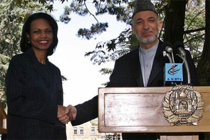 Hamid Karzai y Condoleezza Rice se chocan la mano durante la breve visita de la secretaria de Estado de EE UU a Kabul.