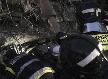 Los bomberos entran en un orificio para inspeccionar el vehículo donde han encontrado el cadáver de Carlos Alonso Palate.