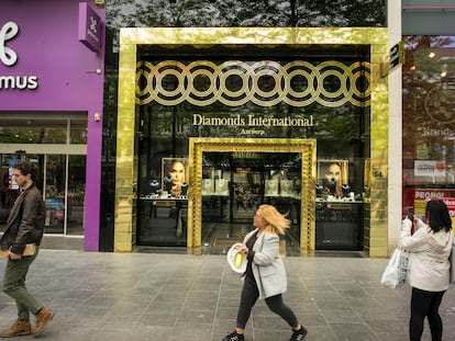 A woman walks past the window of a jewelry store in Antwerp, Belgium.