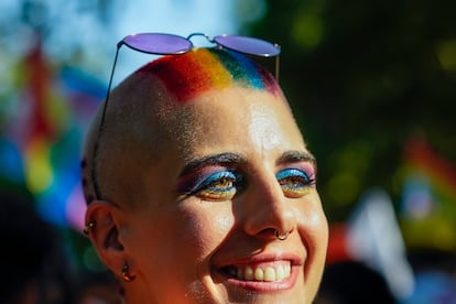 Primer plano de una mujer con el pelo y los ojos pindados con los colores del arcoíris.