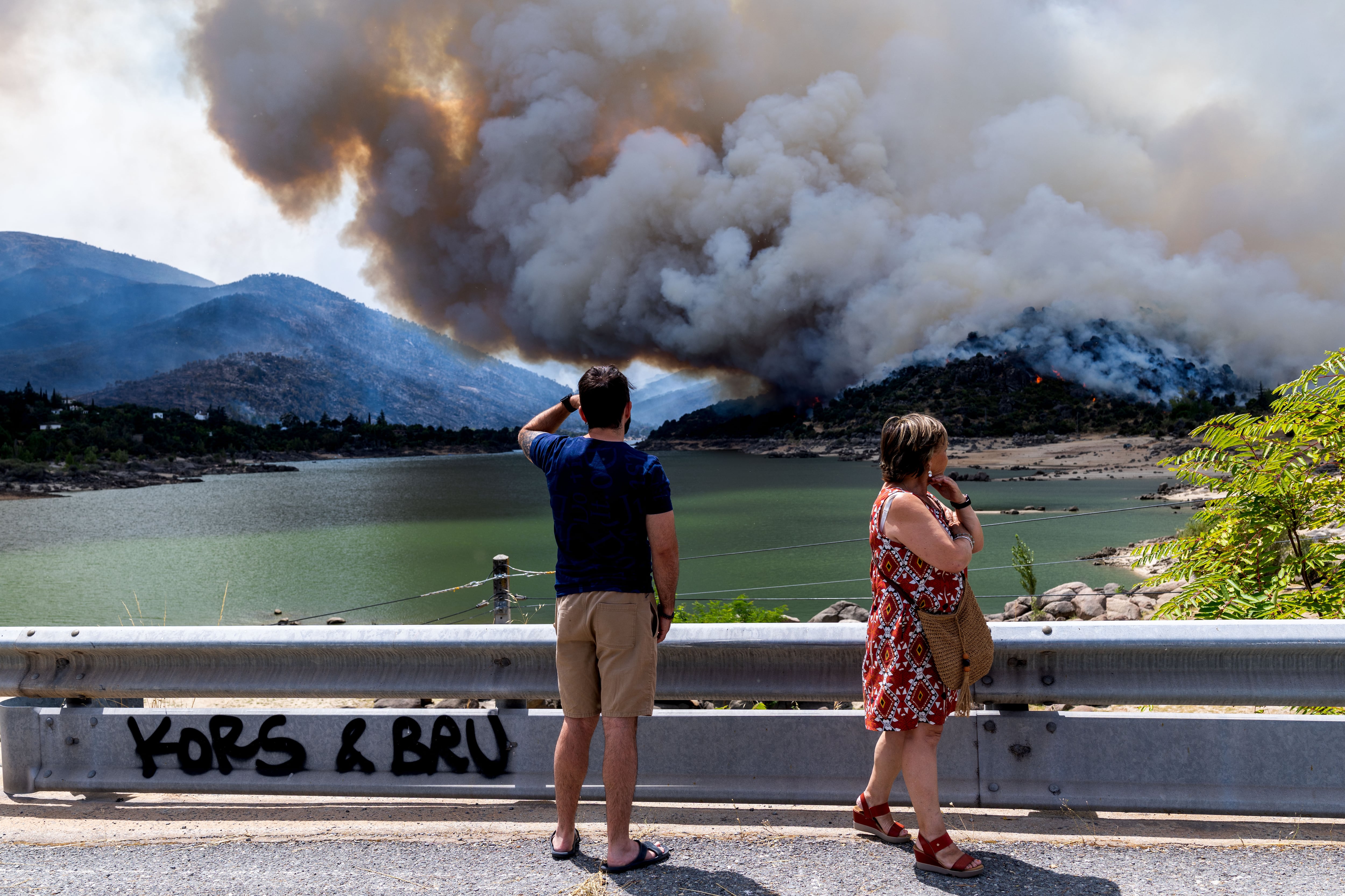 Algunos curiosos observan el incendio sobre el embalse del Burguillo (Ávila), el pasado 25 de julio.
