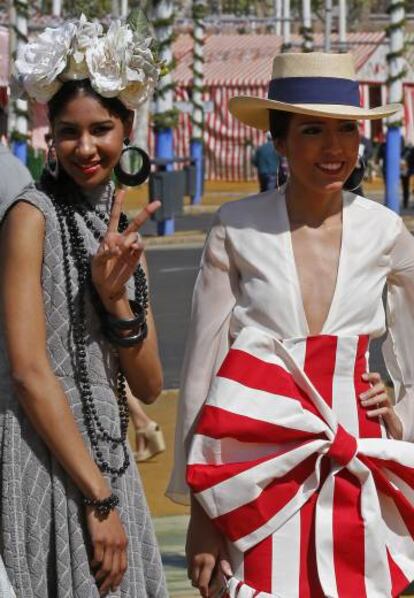 Dos j&oacute;venes pasean por el Real de la Feria de Abril. 