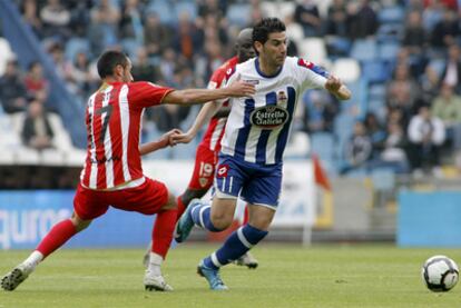 Ortíz, del Almería, trata de evitar el avance de Riki, del Deportivo.