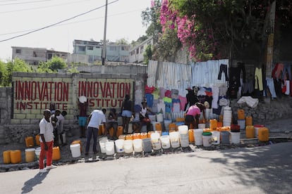 People line up along a street to collect water in buckets and containers after Haiti's Prime Minister Ariel Henry pledged to step down following months of escalating gang violence, in Port-au-Prince, Haiti March 12, 2024