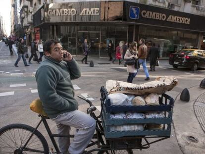 Un vendedor ambulante de comida se detiene frente a una casa de cambio del centro financiero de Buenos Aires.