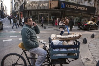 Un vendedor ambulante de comida se detiene frente a una casa de cambio del centro financiero de Buenos Aires.