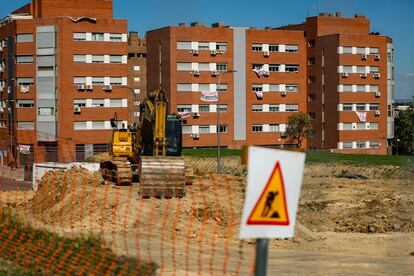 Una retroexcavadora aparcada, el 22 de septiembre, en la parcela donde se construirá el cantón auxiliar de Vicálvaro. Al fondo, los vecinos han colgado carteles y lonas con mensajes contra la obra.