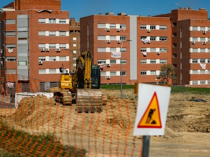 Una retroexcavadora aparcada, el 22 de septiembre, en la parcela donde se construirá el cantón auxiliar de Vicálvaro. Al fondo, los vecinos han colgado carteles y lonas con mensajes contra la obra.