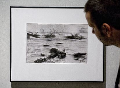 Un visitante ante una de las famosas imágenes del desembarco de Normandia que captó Robert Capa el 6 de junio de 1944. El fotografo desembarcó con los soldados americanos en la playa de "Omaha", y pudo disparar cuatro carretes de fotografías. Desgraciadamente, una vez en Londres, el ayudante de laboratorio las destruyó al secarlas. Se salvaron sólo once, de las que en la exposición se exhiben diez.