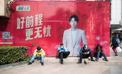 Cuatro repartidores utilizan sus móviles en Shangai, el pasado febrero.