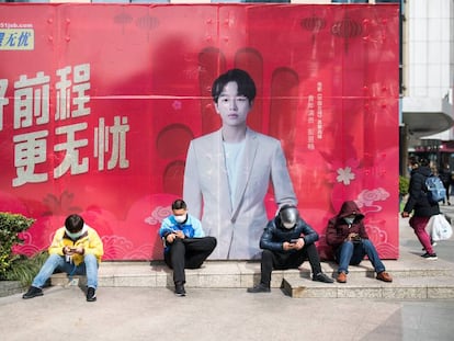 Cuatro repartidores con mascarillas junto a una boca de metro en Shangai, el 27 de febrero pasado.