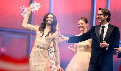 Conchita Wurst (i), representante de Austria, celebra su victoria en el 59&ordm; Festival de Eurovisi&oacute;n junto a los presentadores de la gala.