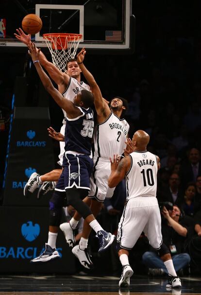 Kevin Durant, de Oklahoma City Thunder, lanza ante tres jugadores de Brooklyn Nets.