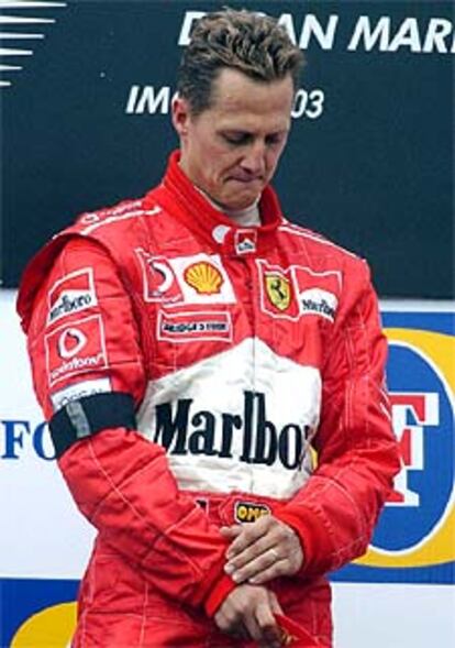 Schumacher, con un brazalete negro por la muerte de su madre esta mañana, llora en el podio de Imola tras su victoria en el Gran Premio de San Marino.